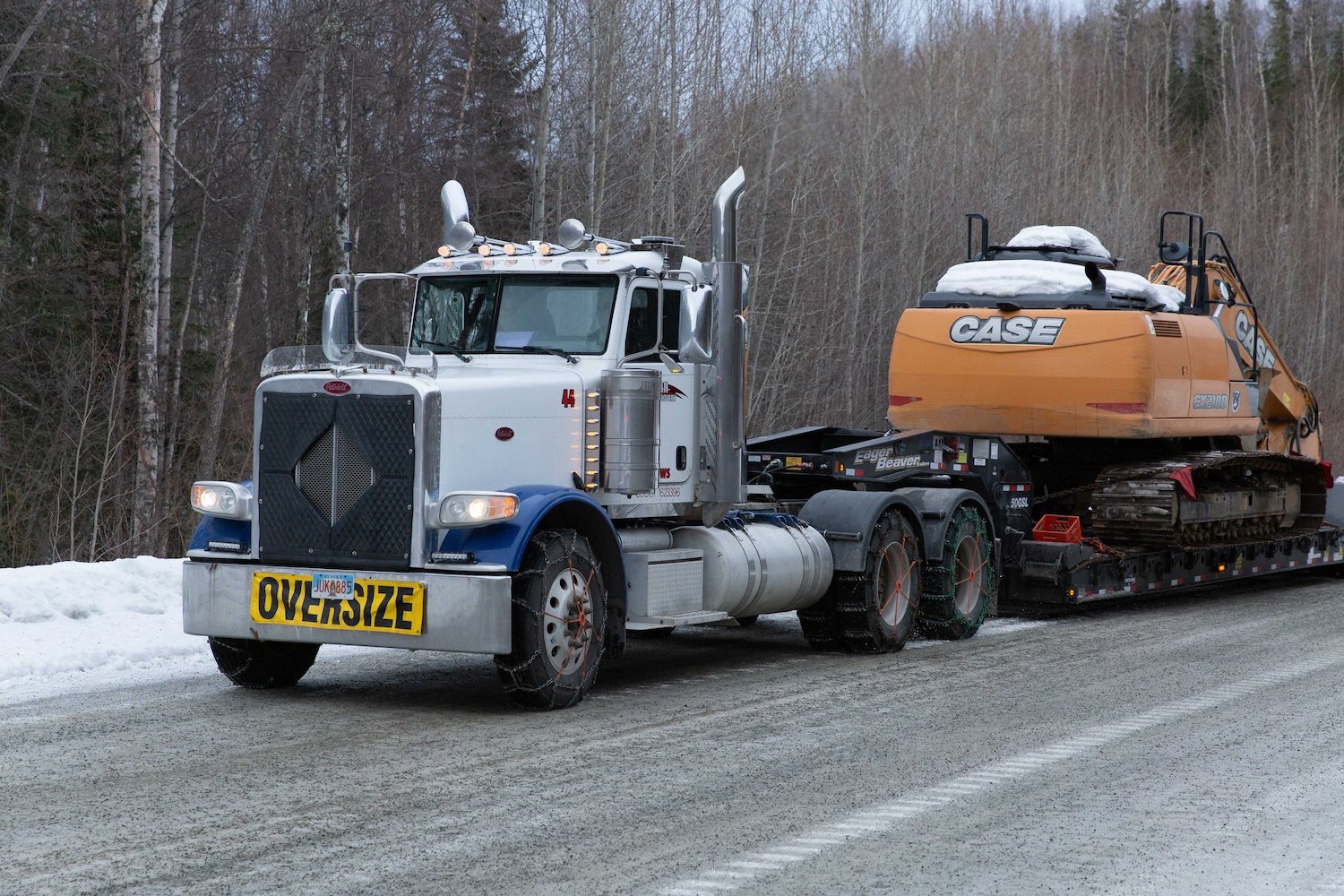 Vulcan Contracting heavy haul carrying a rental excavator on a highway located in Anchorage, Alaska